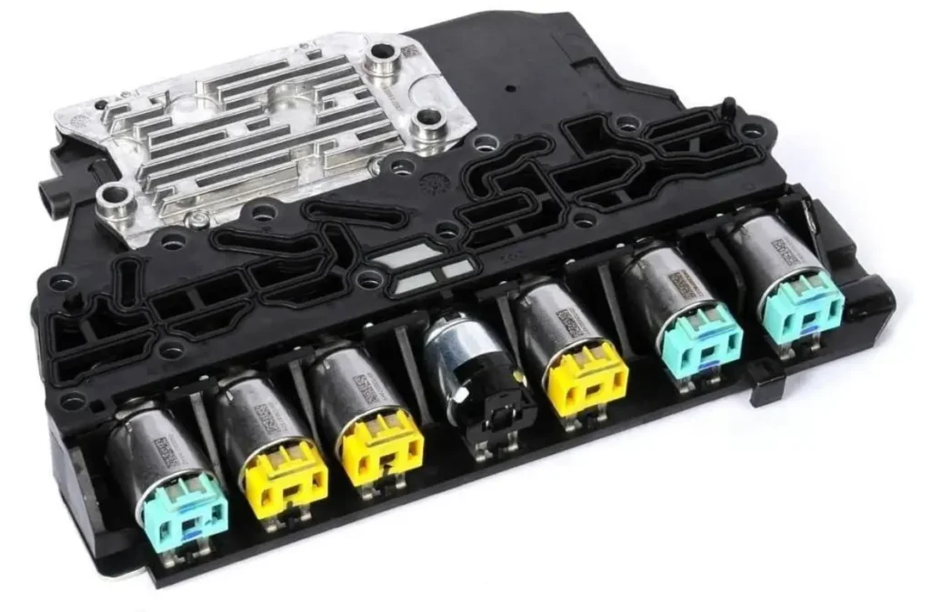 A close-up view of a Transmission Control Module (TCM) with several solenoids attached.